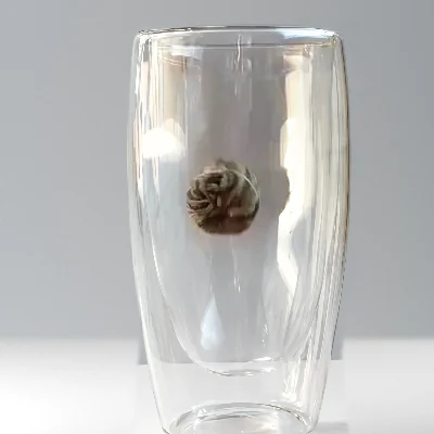 A tea ball dropping into a clear glass