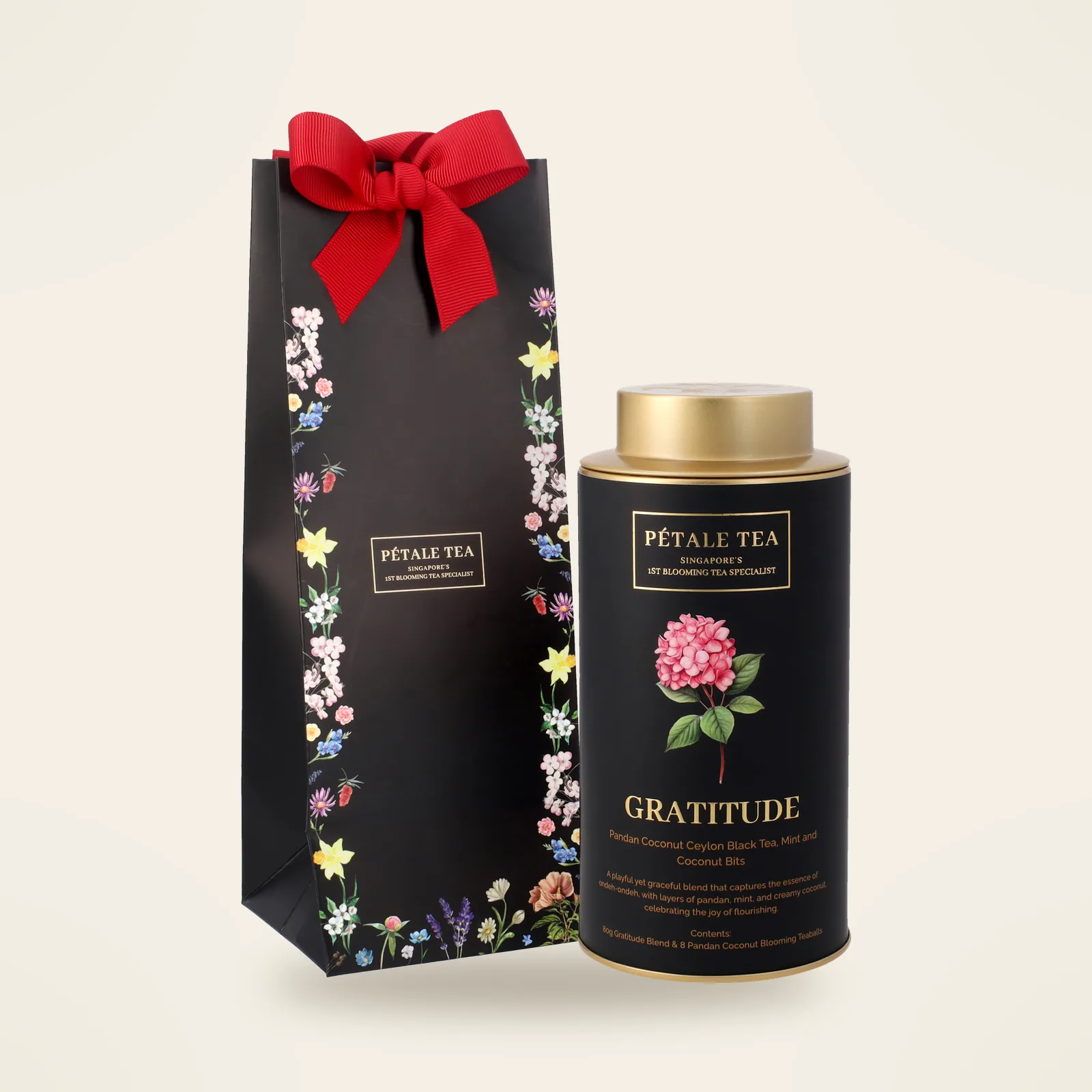A Gratitude Classic tin with its black gift bag and red ribbon